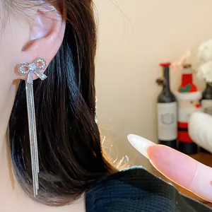 Elegant close-up view of sparkling zircon bow stud earrings with long silver tassels