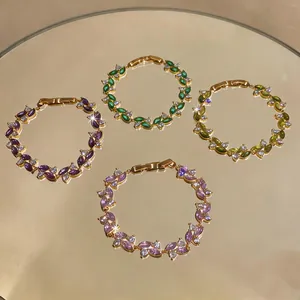 Primo piano di bracciali placcati in oro con zirconi colorati taglio marquise.