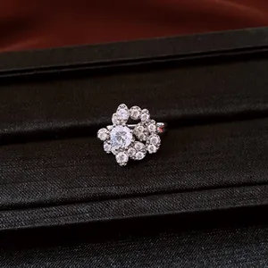 Close-up of a sparkling cubic zirconia floral ear clip on a black velvet tray