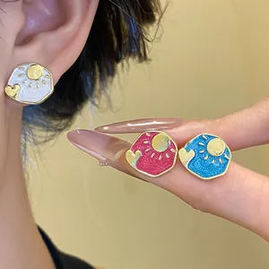 Detail shot of vintage enamel sun and heart stud earrings in white, pink, and blue.