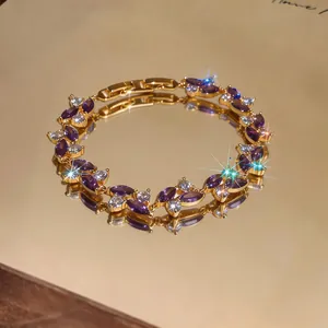 Dettaglio di un elegante bracciale placcato oro con zirconi marquise viola e bianchi