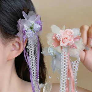 Nahaufnahme eleganter lila und rosa Spitzenblumen-Haarspangen mit feinen Perlenquasten.