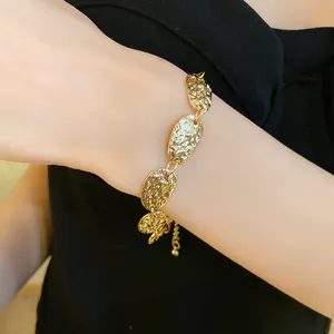 Vista detallada de una pulsera dorada con eslabones metálicos ovalados texturizados en modelo