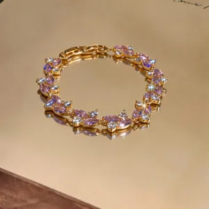 Dettaglio di un elegante bracciale placcato oro con zirconi marquise viola e chiari
