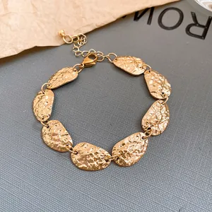 Primer plano detallado del acabado martillado de una pulsera de eslabones ovalados dorados