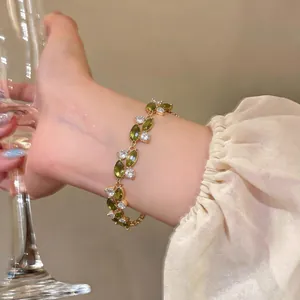 Vista dettagliata di un elegante bracciale placcato oro con zirconi verdi a taglio marquise.