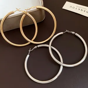 Close-up view of elegant gold and silver large metal hoop earrings for women's fashion