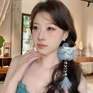 Detailansicht eines eleganten blauen Spitzenblumen-Haarclips mit Perlenquasten