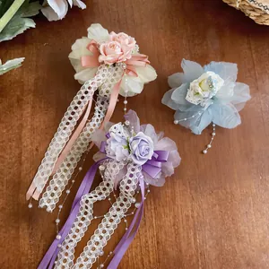 Nahaufnahme von eleganten lila blauen und rosa Spitzenblumen Haarspangen auf Holz