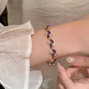 Primo piano di un elegante bracciale placcato oro con zirconi marquise viola e chiari