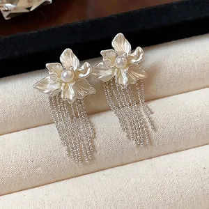 Elegant floral stud earrings with pearl centers and long silver ball chain tassels
