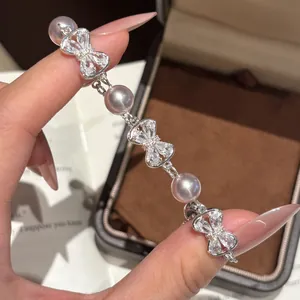 Gedetailleerd macro-overzicht van elegante zirkoonstrik en parelarmband op hand