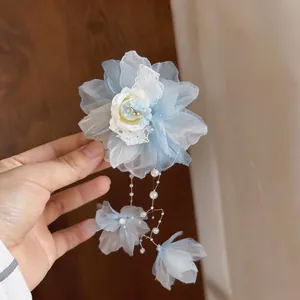 Nahaufnahme einer eleganten blauen Spitzenblumen-Haarspange mit feinen Perlenketten