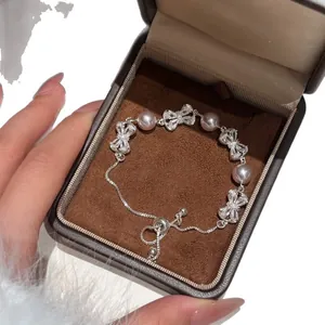 Elegante armband met zirkoon strik en parels met verstelbare schuifketting.