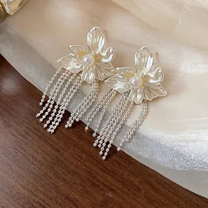 Elegant silver flower tassel earrings featuring a pearl center and dangling ball chains.