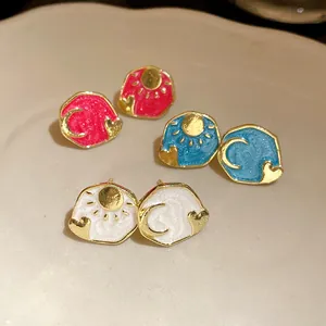 Detailed view of vintage enamel earrings featuring gold-plated sun, moon, and heart motifs.