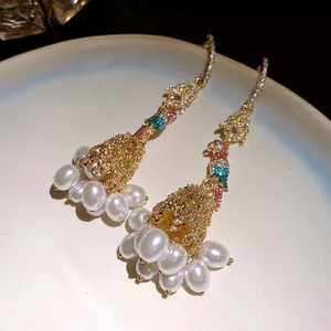 Close-up detail of luxury parrot tassel earrings with sparkling crystals and white pearls