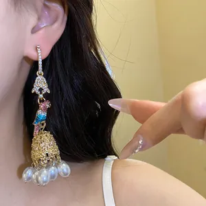 Close-up of ornate parrot earring with pearls and colorful crystals on model