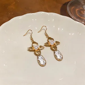 French vintage leaf and flower pearl drop earrings presented on a white scalloped plate