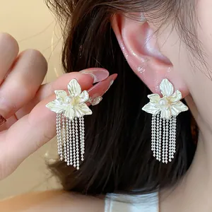 Elegant floral tassel earrings with pearls, detailed close-up showing silver needle design.