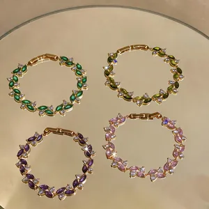 Dettaglio di quattro eleganti bracciali in zircone placcato oro in vari colori
