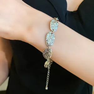 Primer plano detallado de una pulsera de eslabones ovalados martillados en plata.