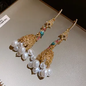 Detailed view of luxury parrot tassel earrings with pearls and colorful crystals
