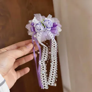 Detailansicht der lila Spitzenblumen-Haarklammer mit eleganten Perlen- und Bandanhängern