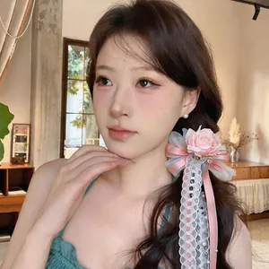 Nahaufnahme einer exquisiten rosa Rosen-Haarklammer mit Spitze und Bändern im Haar