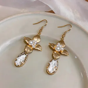 Detail view of vintage French gold leaf earrings with pearls and teardrop crystals