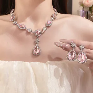Detail view of an elegant jewelry set with pink teardrop stones and shiny rhinestones.