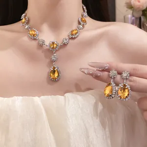 Detailed view of elegant yellow teardrop necklace and earrings set worn by model