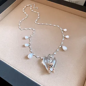 Close-up detail of a vintage heart necklace with a cute flocked teddy bear and pearl charms