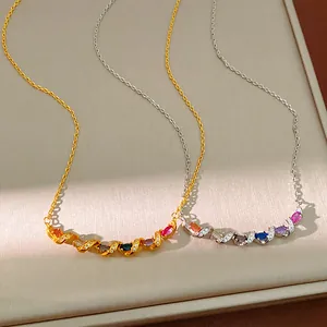 Close-up of twisted gold and silver necklaces with colorful marquise-cut gemstones