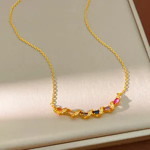 Detailed macro view of elegant gold twisted necklace featuring vibrant colorful zircon stones