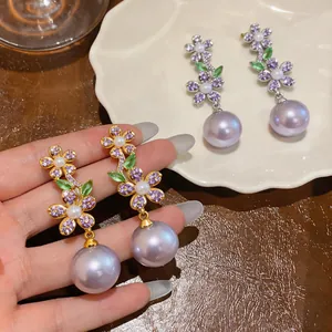 Detailed view of French luxury zircon flower earrings with purple pearls and leaves