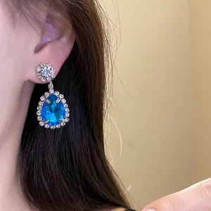 Close-up view of elegant blue water drop pendant earring with sparkling rhinestone detail