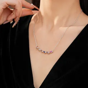 Close-up detail of elegant twisted silver necklace featuring colorful zircon stones on a model