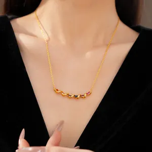 Close-up detail of a delicate gold twisted necklace featuring multi-colored zircon stones