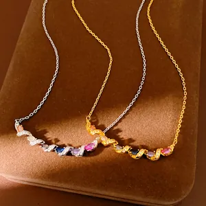 Detail of two elegant twisted necklaces with multi-colored zircons on a brown display box