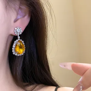 Elegant yellow teardrop pendant earrings with sparkling rhinestone halo for women's fashion.