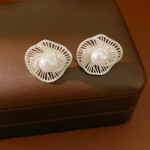 Vista dettagliata di eleganti orecchini a lobo in argento a forma di fiore con perla bianca