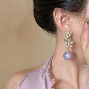 Detailed close-up of floral zircon pearl drop earrings worn by a model in French style