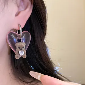 Detail view of a cute flocked brown bear heart earring with pink transparent finish.