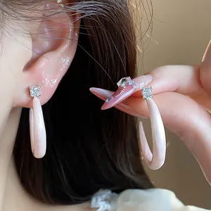Vista detallada de elegantes pendientes de aro en C de esmalte rosa con circonitas.
