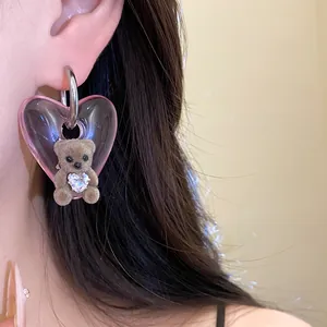 Macro view of cute flocked teddy bear detail on a pink translucent heart drop earring