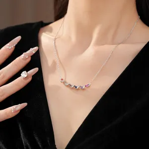 Close-up of a twisted silver necklace set with vibrant colorful zirconia stones.