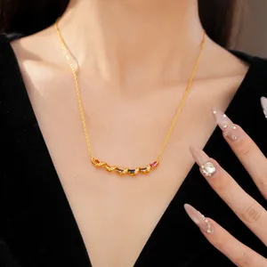 Detail of elegant gold twisted bar necklace with multi-colored gemstones on a model