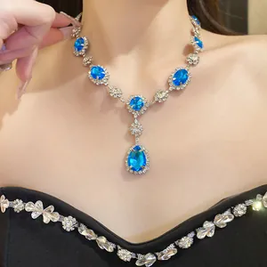 Detailed view of luxurious blue water drop rhinestone pendant necklace worn by a model