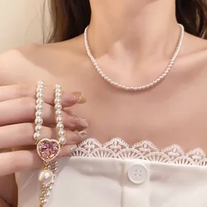 Eleganter weißer Perlenchoker und Halskette mit rosa Herzanhänger für Damen am Modell